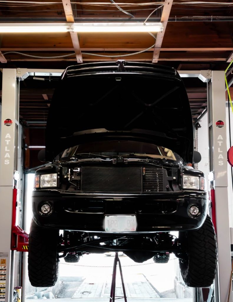 a lifted Dodge Ram mounted on an Atlas Automotive Equipment two-post vehicle lift