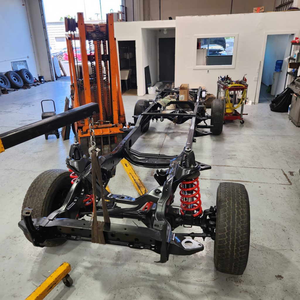 a frame-off automotive restoration featuring a fully stripped, repainted, and rebuilt ladder-style chassis