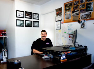 a person sitting at a desk in J&S Automotive Repair Shop