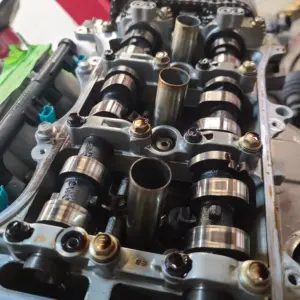 an open cylinder head, revealing the camshafts, cam caps, and spark plug tubes